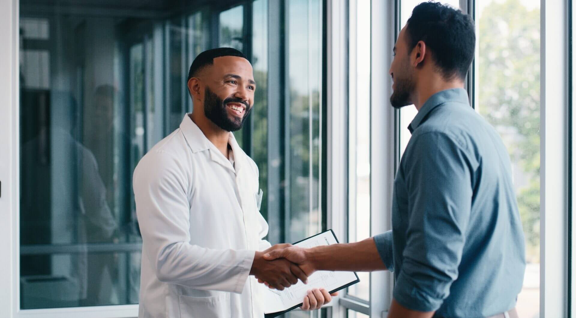 Two men shaking hands in a professional setting.